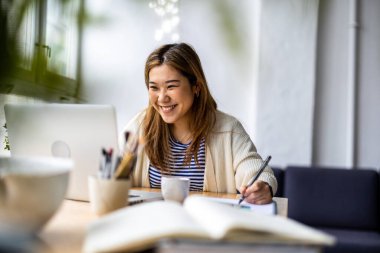 Young womansitting at desk working on laptop