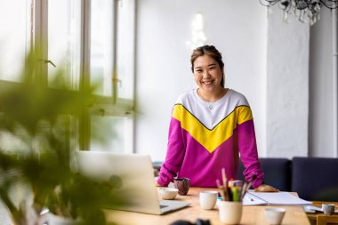 Young female freelancer working in loft office