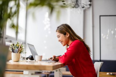 Young womansitting at desk working on laptop