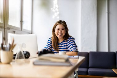 Young womansitting at desk working on laptop