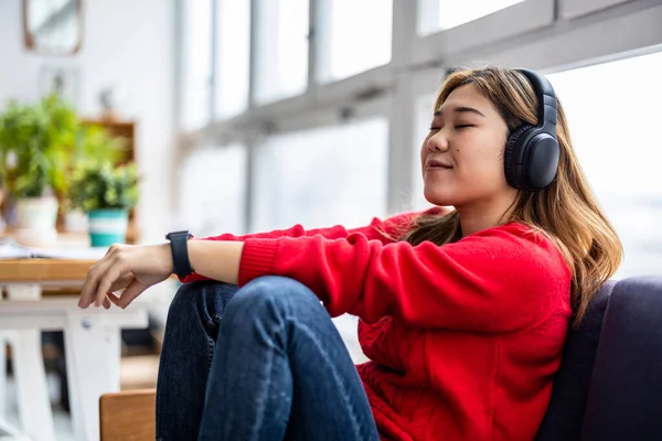 Young Woman Using Headphones While Relaxing Sofa Stock Snímky