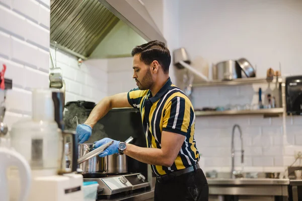 stock image Young man preparing fresh food in commercial kitchen