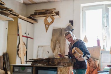 Marangozluk atölyesinde dizüstü bilgisayar kullanan kadın marangoz.