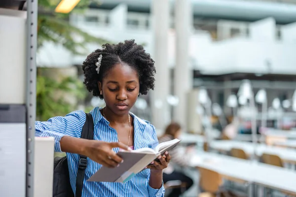 Черная Студентка Читает Книгу Библиотеке — стоковое фото
