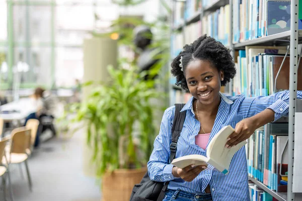 Μια Μαύρη Μαθήτρια Διαβάζει Ένα Βιβλίο Μια Βιβλιοθήκη — Φωτογραφία Αρχείου