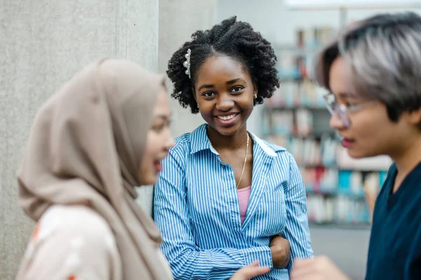 stock image Group of multiethnic students having a discussion in a library