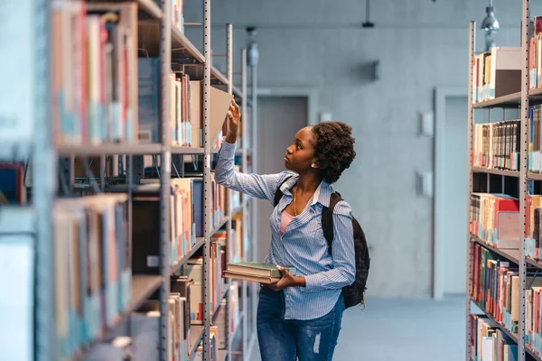 Μαύρη Φοιτήτρια Διαλέγει Βιβλίο Από Βιβλιοθήκη Στη Βιβλιοθήκη — Φωτογραφία Αρχείου