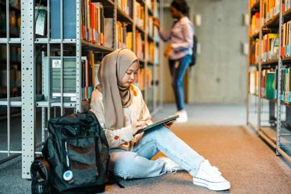 Feminino Estudante Muçulmano Sentado Chão Biblioteca Livro Leitura Com Amigo — Fotografia de Stock
