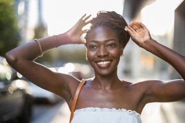 şehirde gülümseyen güzel bir genç kadının portresi