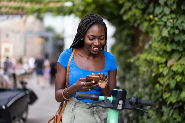 Şehirde Elektrikli Scooterla Dururken Akıllı Telefonunu Kullanan Mutlu Genç Bir — Stok fotoğraf