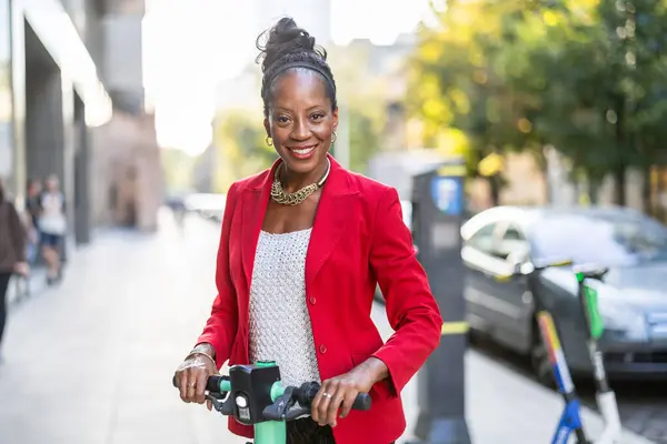 Portrait of a businesswoman with electric scooter in the city