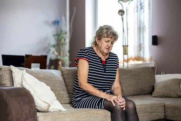Elderly Woman Sitting Sofa Home Suffering Knee Pain — Stock Photo, Image