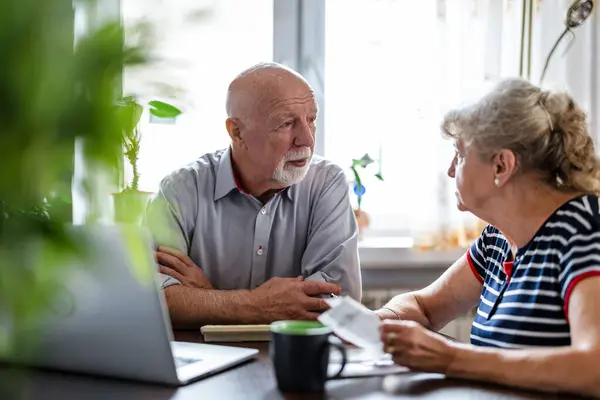 Oudere Echtparen Bespreken Hun Eigen Financiën Terwijl Aan Tafel Zitten Stockafbeelding