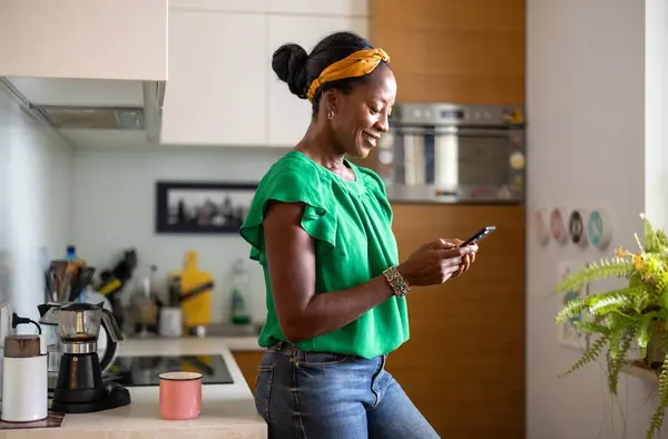 Gülümseyen Kadın Evde Mutfakta Smartphone Kullanarak — Stok fotoğraf
