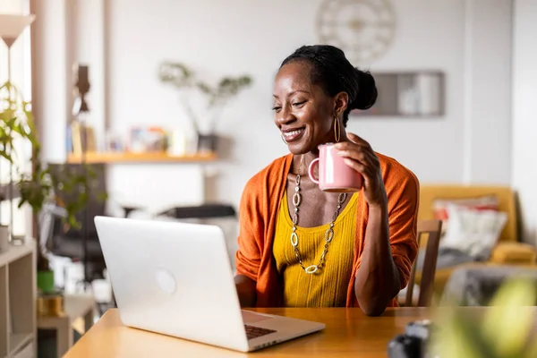 Smiling woman working on laptop at home