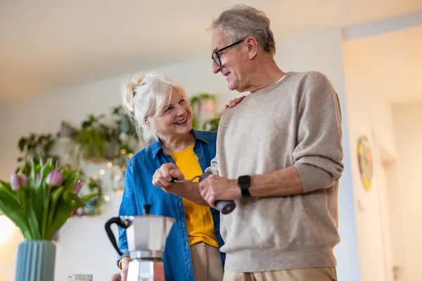 Seniorenpaar Bereitet Hause Kaffee lizenzfreie Stockfotos