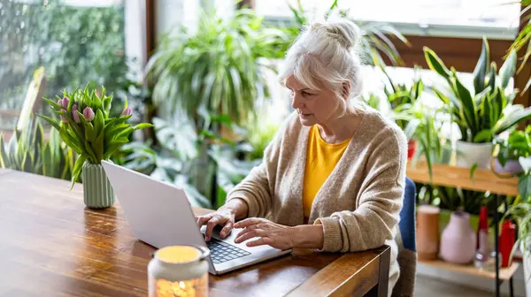 Starší Žena Pomocí Notebooku Zatímco Sedí Stolu Doma Stock Snímky