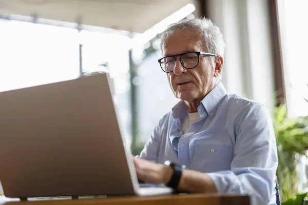 Senior Man Met Laptop Thuis Stockafbeelding