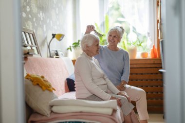 Huzurevinde bakıcısı olan yaşlı bir kadın.