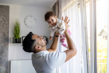 Mutlu baba evde küçük kızıyla oynuyor.