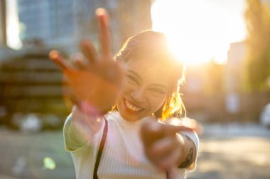 Şehrin sokaklarında dans eden gülümseyen genç kadın