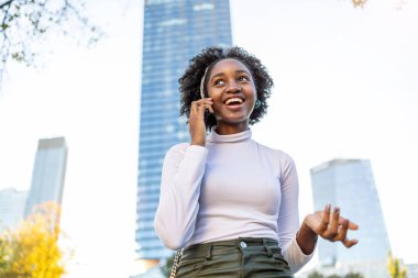 Şehirde cep telefonu kullanan genç bir kadının portresi