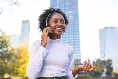 Şehirde cep telefonu kullanan genç bir kadının portresi