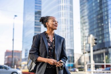 Şehirde cep telefonu kullanan kendinden emin bir iş kadını.