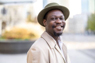 Şehirde şapka takan yakışıklı bir adamın portresi.