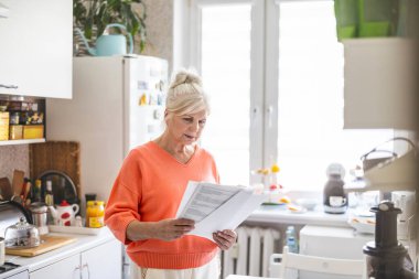 Evdeki mali belgelere bakan kıdemli bir kadın. 