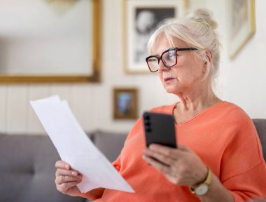 Evdeki mali belgelere bakan kıdemli bir kadın. 