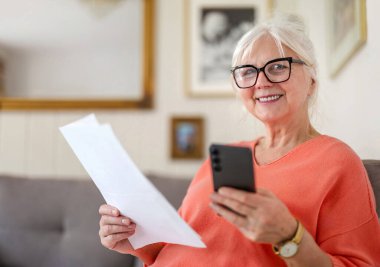 Evdeki mali belgelere bakan kıdemli bir kadın. 