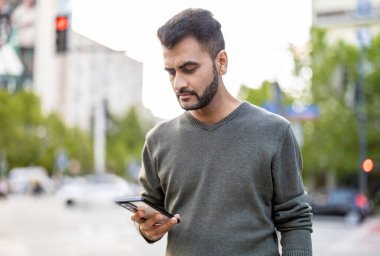 Şehirde cep telefonunu kullanan genç bir adamın portresi.