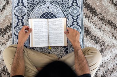 Kuran okuyan Müslüman bir adam, Mat 'ın üzerinde oturuyordu.