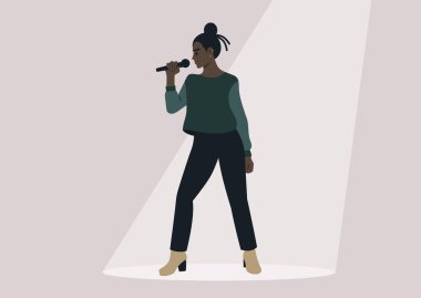 Genç, kendine güvenen bir şarkıcı iyi aydınlatılmış bir sahnede, spot ışıklarının altında bir mikrofon tutuyor.