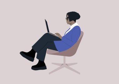 Özgüvenli Afrikalı kadın dizüstü bilgisayarında özenle yazıyor, rahat bir şekilde bir sandalyede oturuyor.