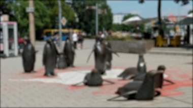 Arka planda yayaların yürüdüğü Chemnitz 'deki penguen anıtının bulanık arkaplanı.