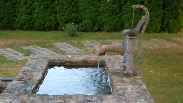 在后院里 一个旧的铸铁手泵水柱配备了一个装饰瀑布喷泉 — 图库视频影像