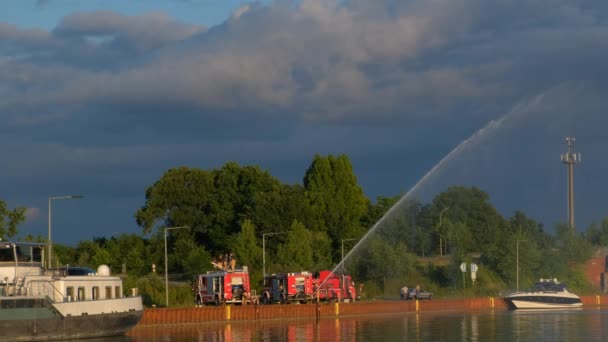在德国 年轻的消防队员在水渠的河岸上练习浇水 — 图库视频影像