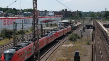 Almanya, Wuppertal, 2022 civarı. Kırmızı bölgesel yolcu treninin Wuppertal-Oberbarmen istasyonuna varışı. Yukarıdan görüntüle.