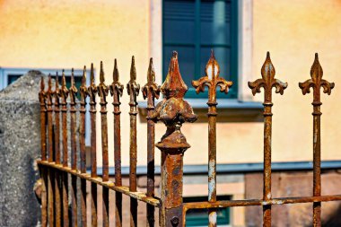 Almanya 'da arka planında bir bina olan paslı demir bir çitin yakın çekimi..