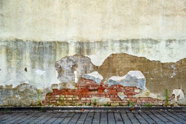 Eski tuğla duvardan süzülen alçı .