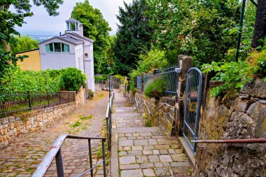Almanya 'da çan kulesi olan beyaz binaya açılan taş yol..
