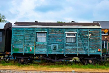 İstasyonda çok eski, ahşap, yeşil renkli bir yolcu vagonu var..