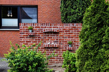 Almanya 'da yanında dekoratif duvar olan kırmızı tuğladan bir ev..