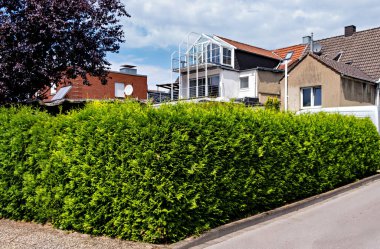 Almanya 'da dekoratif balkonları olan bir evin yanındaki çit..