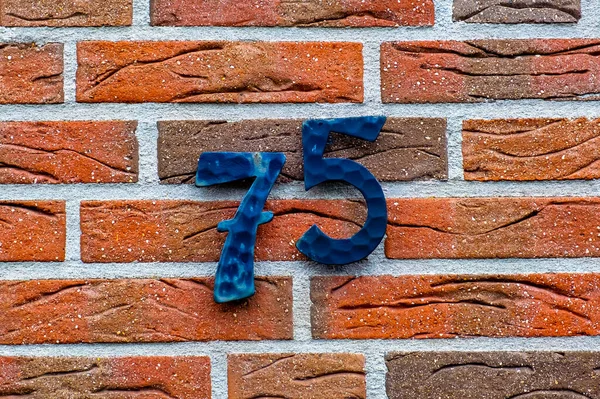 レンガの壁のクローズアップ その上の番号75 — ストック写真