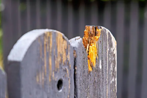 Close-up of a broken wooden fence .