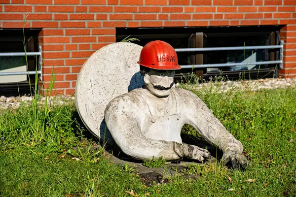 Статуя Человека Красном Шлеме Полуторчащего Люка Земле Возле Жилого Дома — стоковое фото