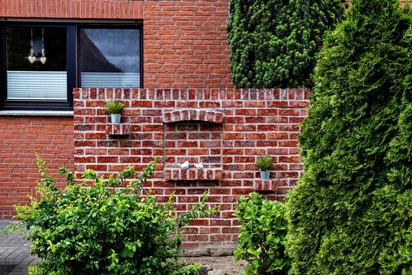 Almanya 'da yanında dekoratif duvar olan kırmızı tuğladan bir ev..